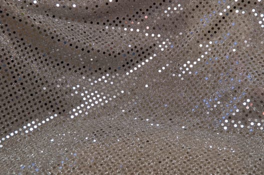 Abstract image of a silver grey sequined piece of fabric typically used to make dancer's costumes or dresses.