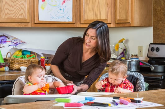 A mother in the kitchen feeds babies breakfast