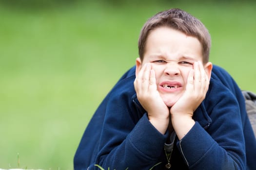 boy outdoors without upper two teeth with pain in the face
