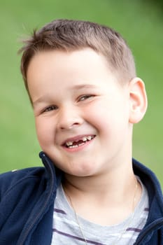 boy outdoors without upper two teeth with smile