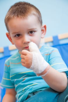 wounded in the left hand with bandage boy at shot in home