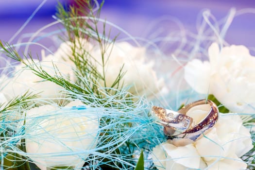 Wedding rings lying on white flower