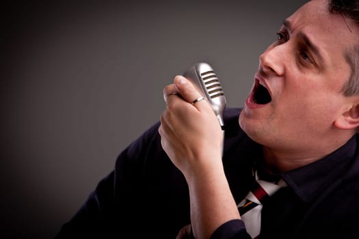 a fifties style singer is singing with an old microphone in his hand