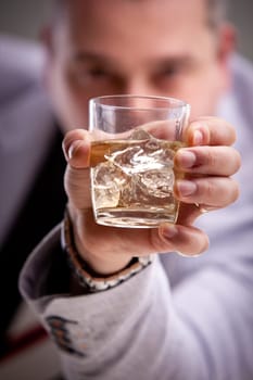 glass of alcoholic drink in man's hand