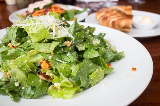 Closed up caesar salad served on wooden table, stock photo