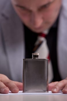 a man watches his flask torn about the challenge of drinking or giving up