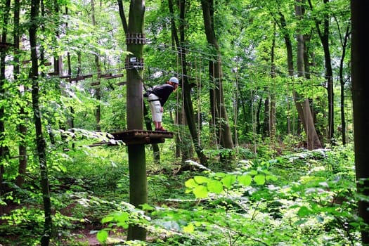 Schwerin,Germany – August 09,2012: The Schwerin climbing forest with obstacle course in the middle of trees and people in protective gear on August 9,2012 in Schwerin.