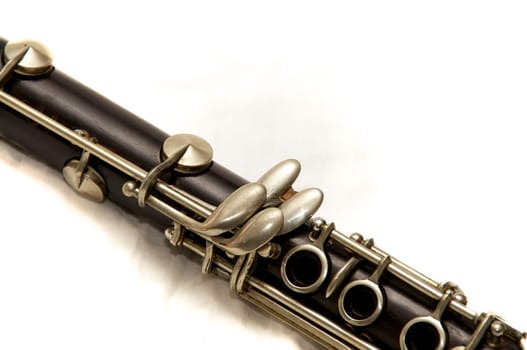 The body of a clarinet musical instrument shot over white.
