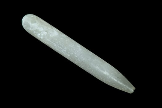 A selenite gypsum wand shot over black.