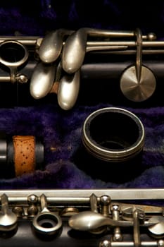 Parts of a clarinet are stored in blue lined case.
