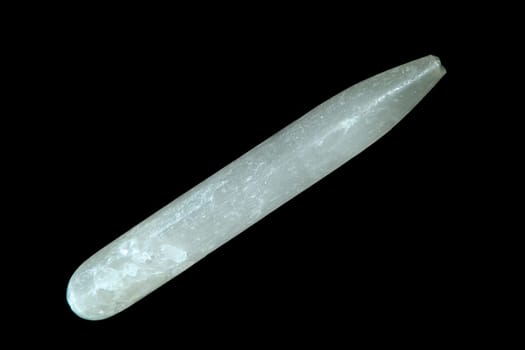 A selenite gypsum wand shot over black.