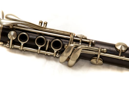 The body of a clarinet musical instrument shot over white.
