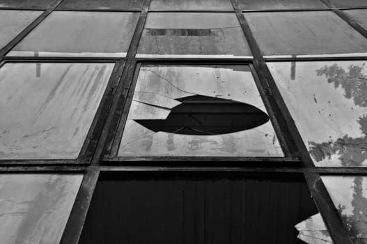 Broken windows with rusty metal frame abstract background. Black and white.