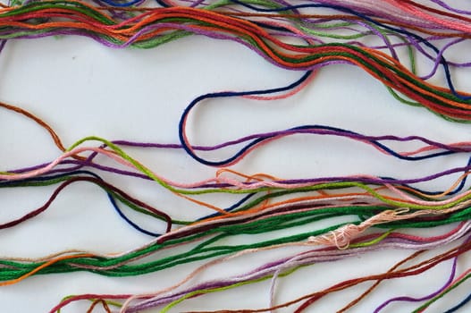 Colorful sewing threads on white background.