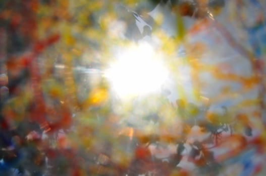 Sun shining through tree branches colorful paint smudged blurry abstraction.