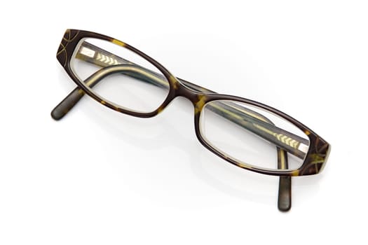 A pair of woman's vintage tortoise shell eyeglasses shot over white.