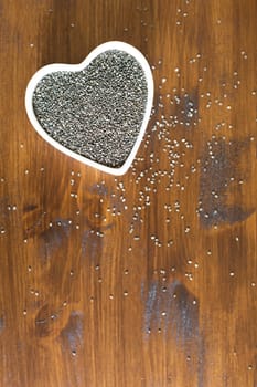 Healthy dark chia seeds in heart container