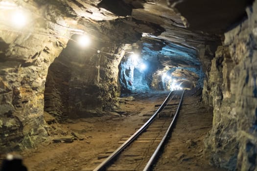 Perspective shot of gold mine tunnel with rail track for chart.