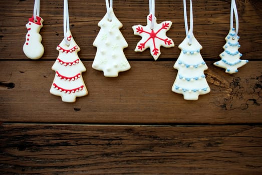 Many Christmas Cookies with Different Decorations Hanging on Wood with Copy Space as Winter or Christmas Background
