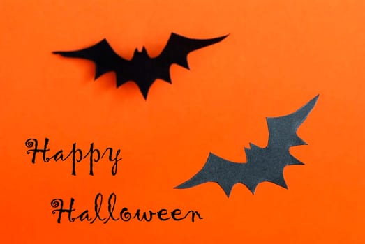 Halloween Background in Orange with two Black Bats and a written Happy Halloween