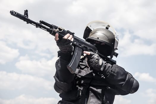 Spec ops soldier in black uniform and face mask with his rifle