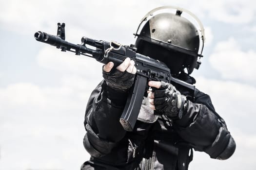 Spec ops soldier in black uniform and face mask with his rifle