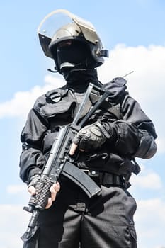 Spec ops soldier in black uniform and face mask with his rifle