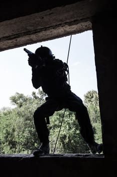 Spec ops soldier in face mask during rope exercises with weapons
