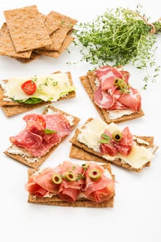 Finnish rye crispbread with salami Milano,Coppa ham,Prosciutto Crudo,Emmentaler,cream cheese with Herbs of Provence and Olive