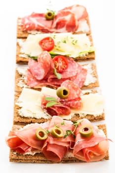 Finnish rye crispbread with salami Milano,Coppa ham,Prosciutto Crudo,Emmentaler,cream cheese with Herbs of Provence and Olive