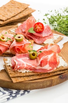 Finnish rye crispbread with salami Milano,Coppa ham,Prosciutto Crudo,Emmentaler,cream cheese with Herbs of Provence and Olive