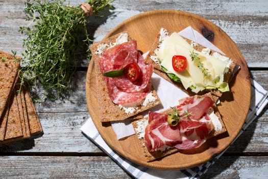 Finnish rye crispbread with salami Milano,Coppa ham,Prosciutto Crudo,Emmentaler,cream cheese with Herbs of Provence and Olive