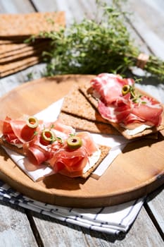 Finnish rye crispbread with salami Milano,Coppa ham,Prosciutto Crudo,Emmentaler,cream cheese with Herbs of Provence and Olive