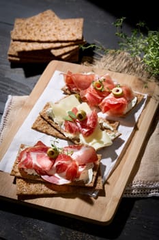 Finnish rye crispbread with salami Milano,Coppa ham,Prosciutto Crudo,Emmentaler,cream cheese with Herbs of Provence and Olive