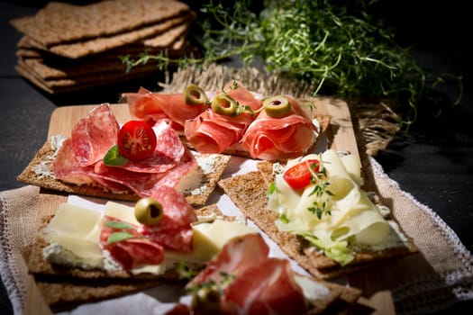 Finnish rye crispbread with salami Milano,Coppa ham,Prosciutto Crudo,Emmentaler,cream cheese with Herbs of Provence and Olive