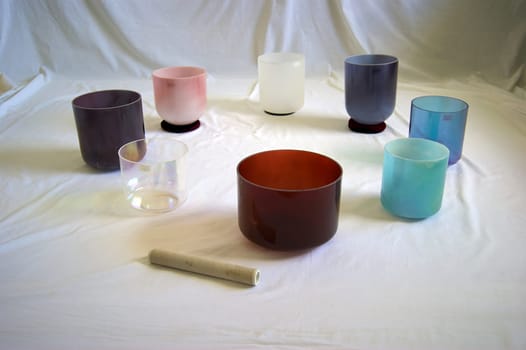 A collection of colorful crystal singing bowls against white backdrop.
