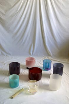 A collection of colorful crystal singing bowls against white backdrop.