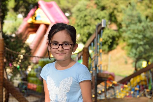 Little girl with glasses having fun in an adventure park