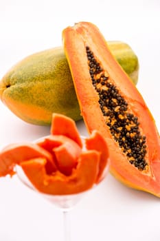 A longitudinal section across the globose body of a papaya fruit does reveal its red-fleshed pulp and countless black seeds in its central cavity..
