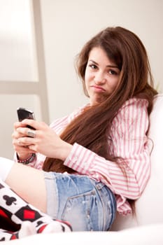 young girl holding a grouch against mobile phone that disappointed her