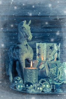 Shabby chic christmas decoration with wooden horse, burning candle and present.