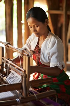 Master weaver is weaving the tapestry with diverse bright threads, close up. Artisanal at work. AI Generated