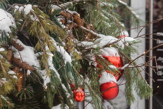 Christmas trees decorated with red balloons in front of the cafe entrance. Street Christmas decorations