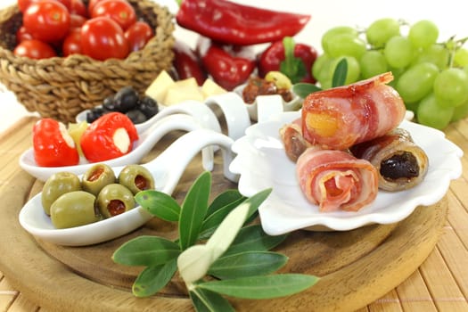 various tapas in serving spoons on a wooden board