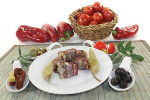 various tapas in serving spoons on a wooden mat