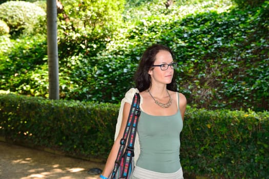 Young woman with glasses walking and having fun in a botanical garden