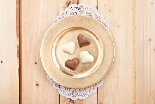 Hearts of white and dark chocolate on a golden plate