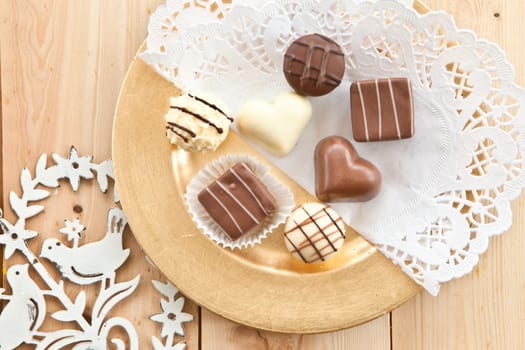 Hearts of white and dark chocolate on a golden plate