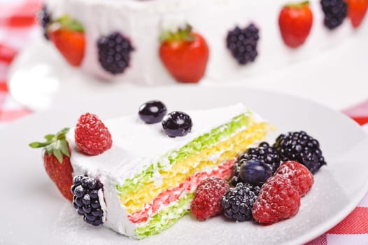 Piece of cake on plate with berries and fruits