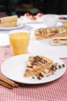 Piece of cake with chokolate and juice on white plate